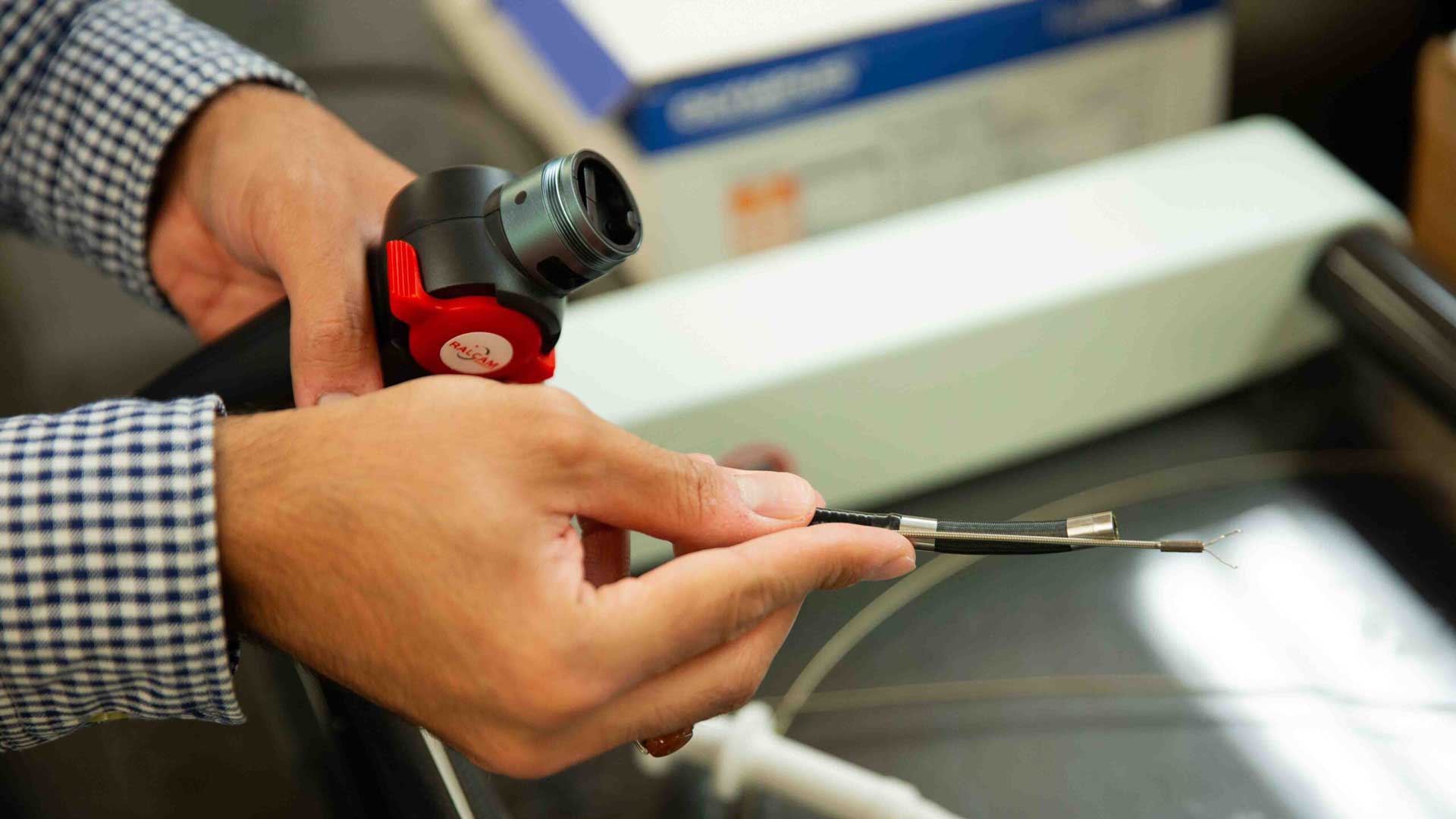 Hands holding lab tools and a pair of wires